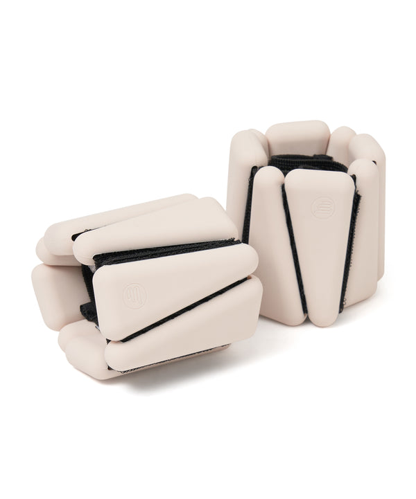A pair of stylish blush-colored wrist weights, each weighing 05kg